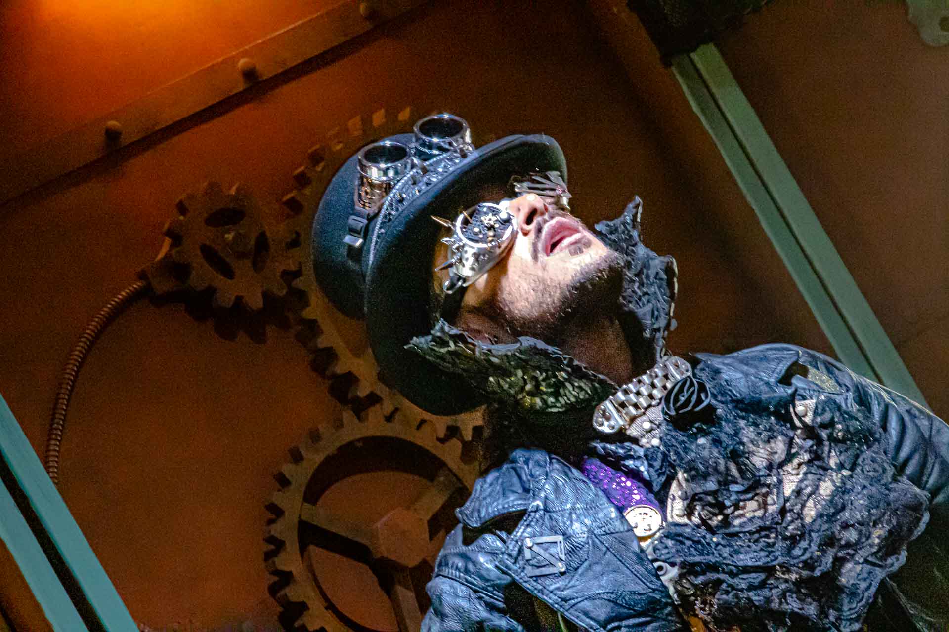 Steampunk cosplayer gazing up at massive gears — Photoshop World